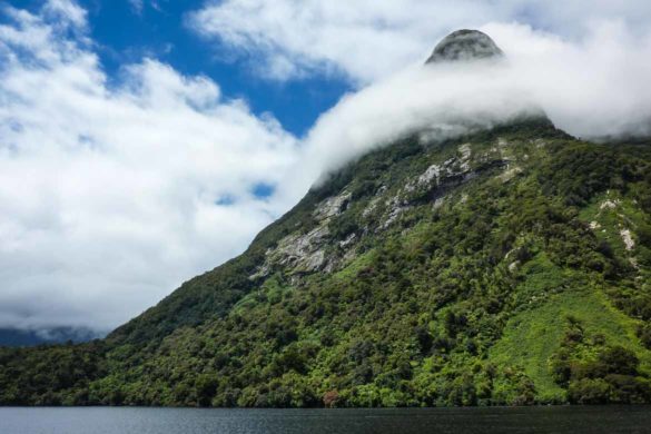 Ein Wolkengürtel um eine Bergspitze erinnert an einen Schal aus zuckerwatte Doubtful Sound Neuseeland