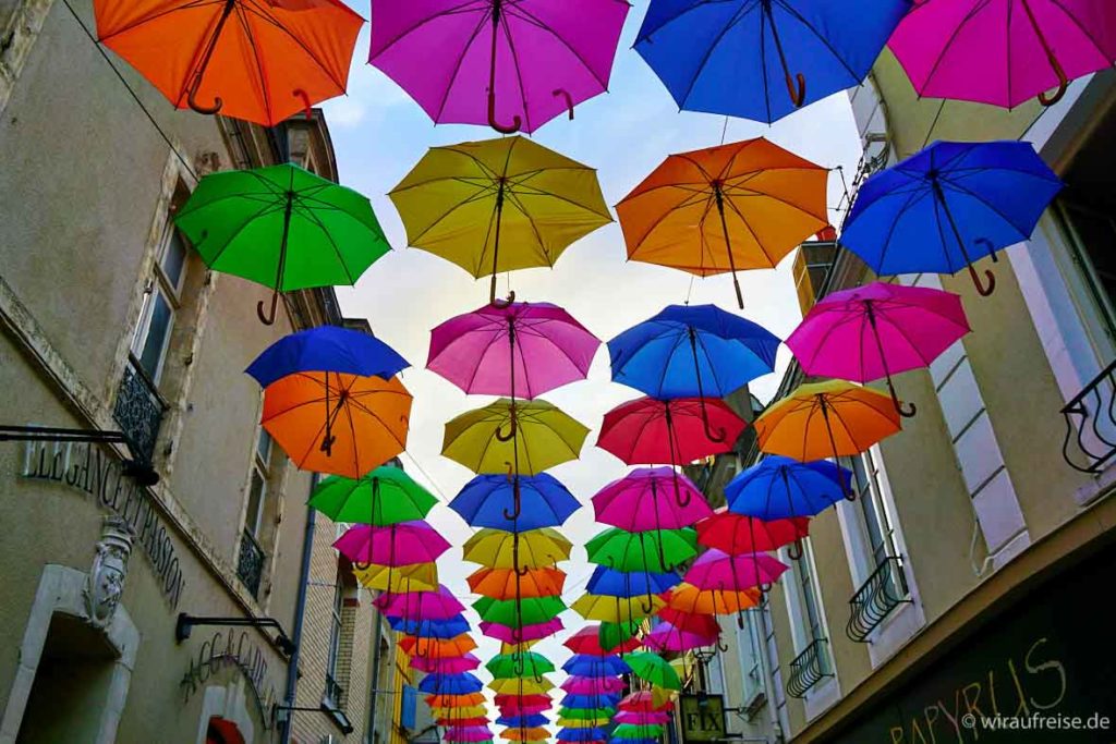 Viele bunte Regenschirme schirmen den Blick zum Himmel ab. Gefunden in einer Gasse in La Ferté-Bernard, Frankreich.